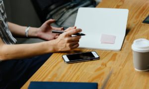 A person reviewing a document while sitting on a table