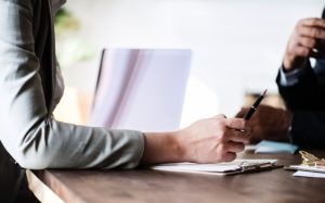 A person holding pen in the hand and reviewing documents